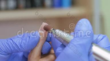 五金美甲，特写，美甲护理美妇在美容院.. 有清漆的美甲。 指甲治疗